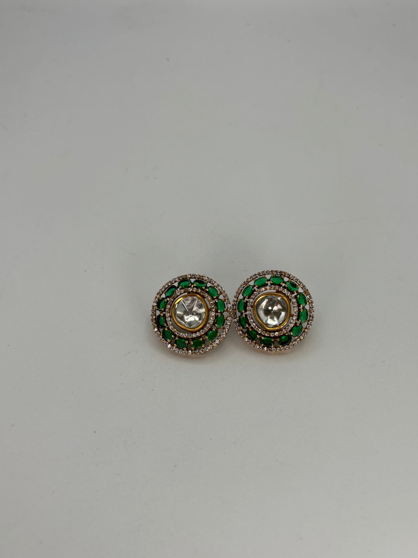Uncut kundan studs with emerald green stones